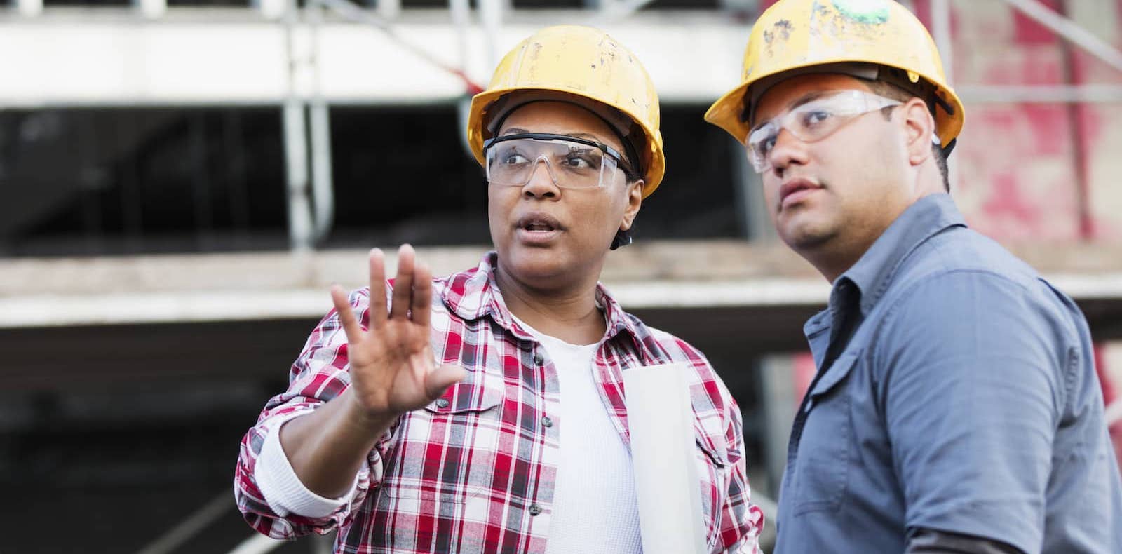 Two workers in hard hats consulting about a project